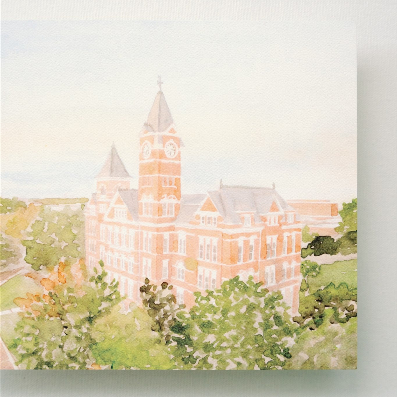 Painting of a large brick building with a clock tower in a park-like setting.
