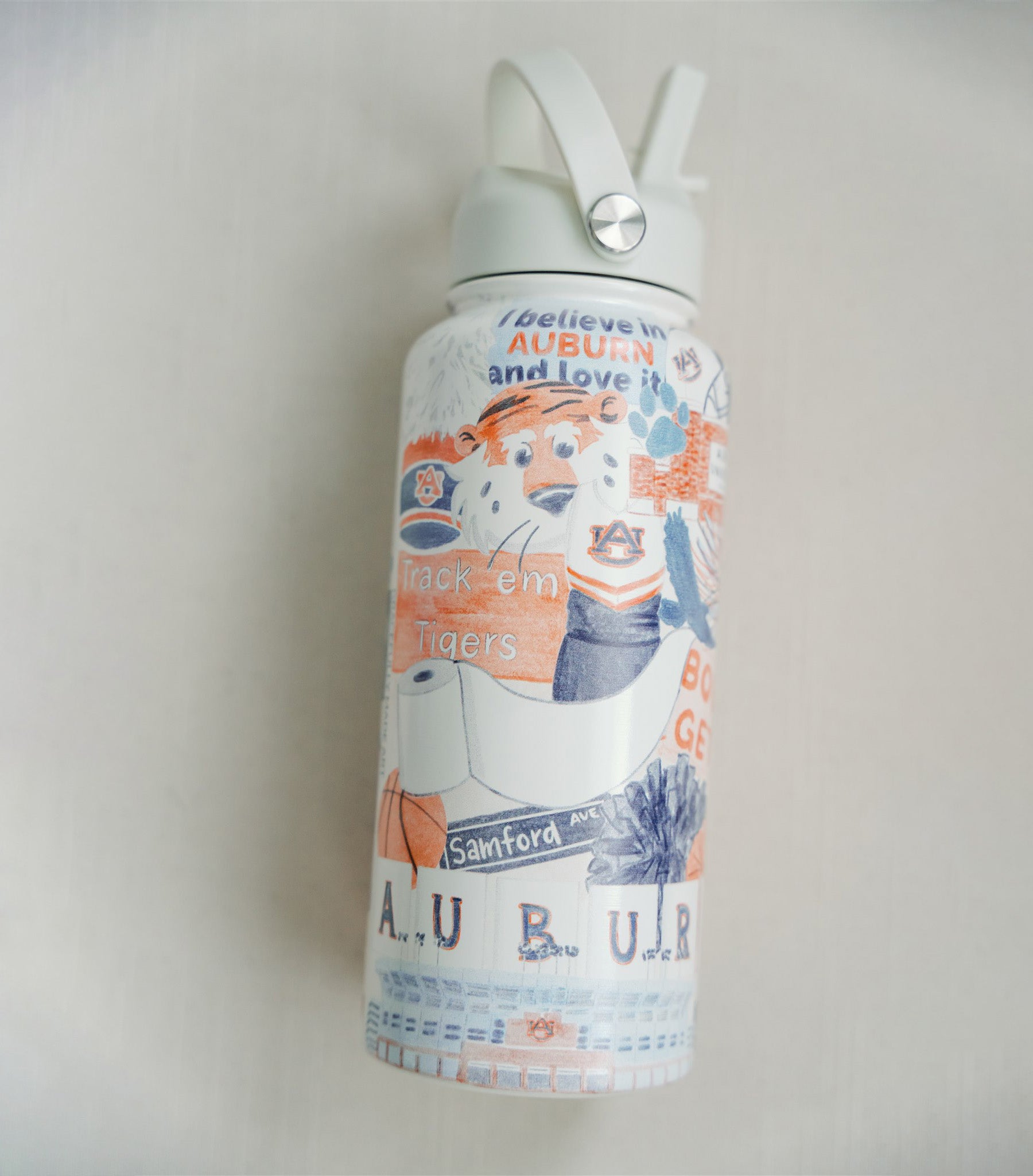 32 ounce water bottle featuring a collage of watercolor illustrations of Auburn University landmarks & icons.