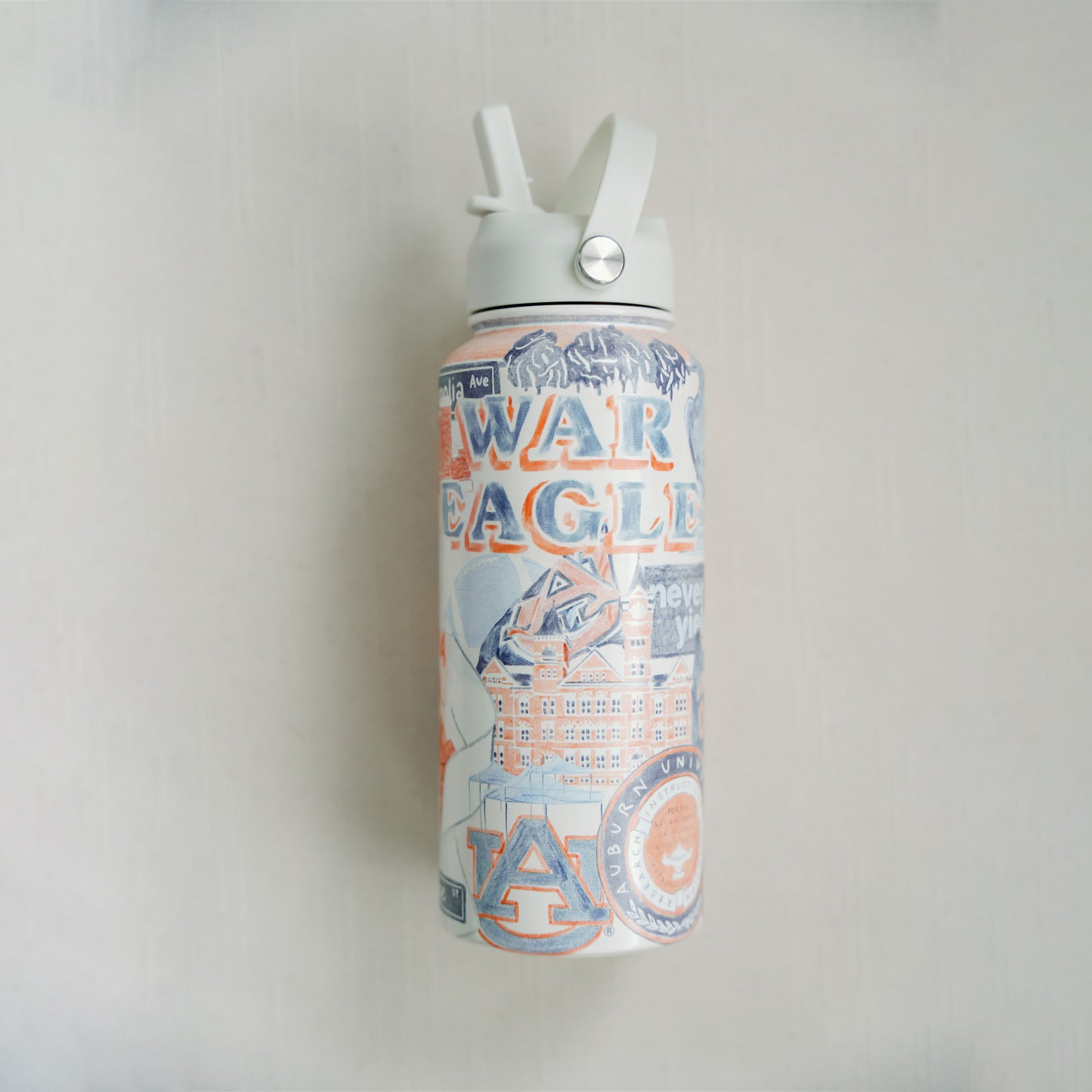 32 ounce water bottle featuring a collage of watercolor illustrations of Auburn University landmarks & icons.