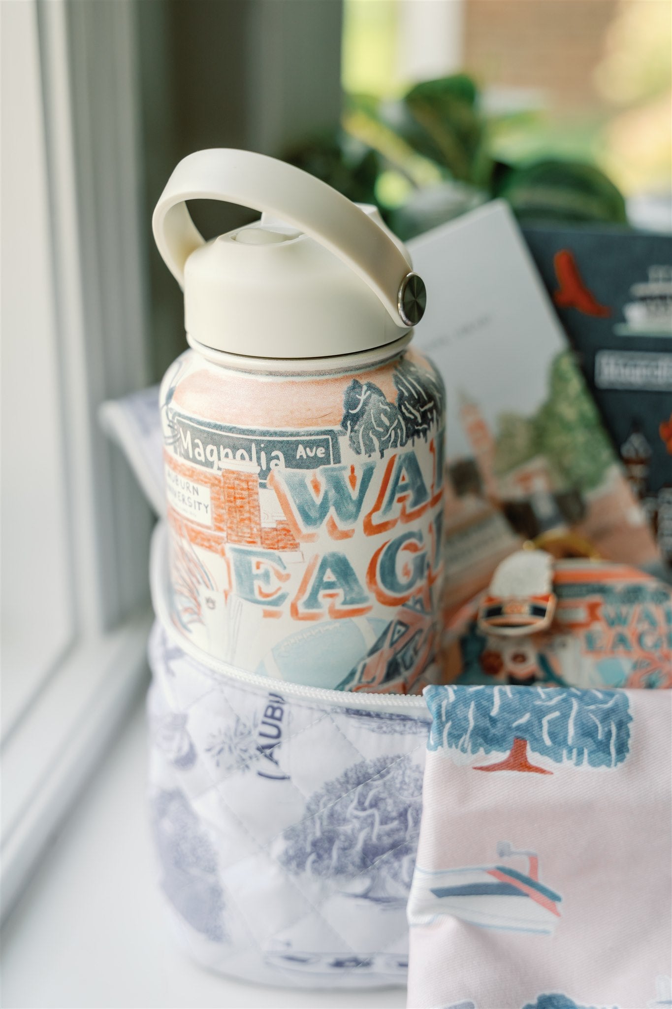 32 ounce water bottle featuring a collage of watercolor illustrations of Auburn University landmarks & icons.