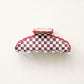 Red and white checkered hair clip on a white background