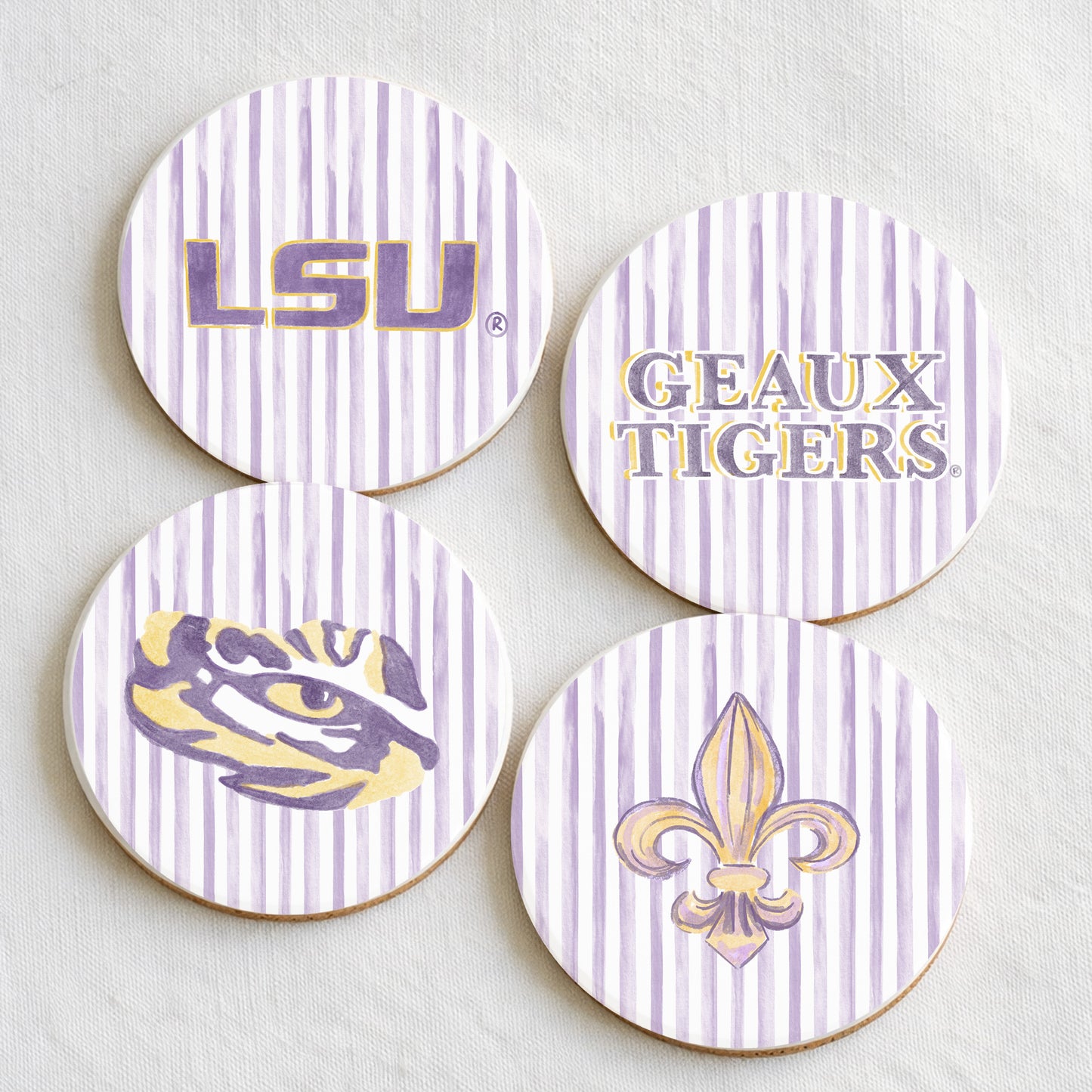 Four LSU-themed coasters with logos and text on a light background