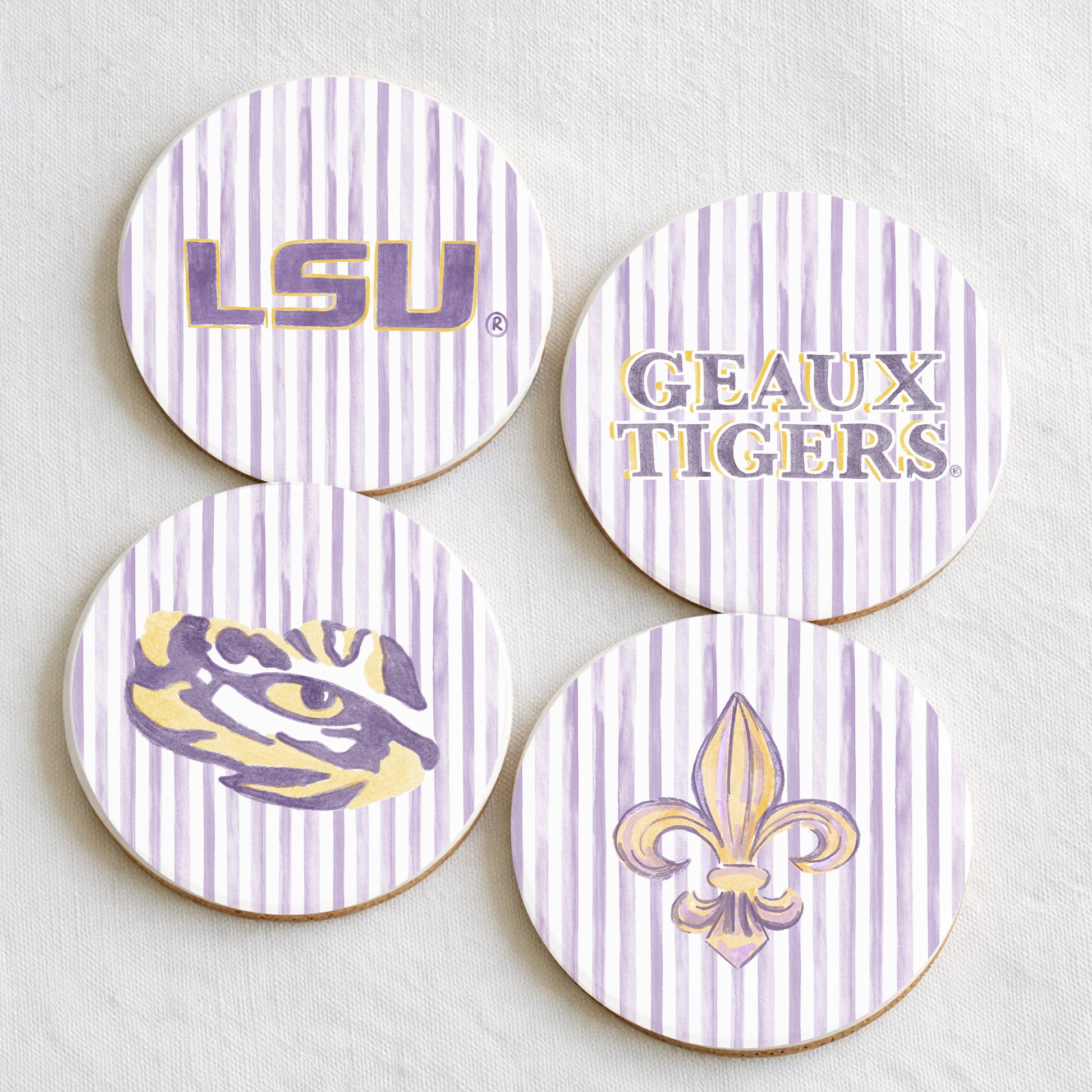 Four LSU-themed coasters with logos and text on a light background
