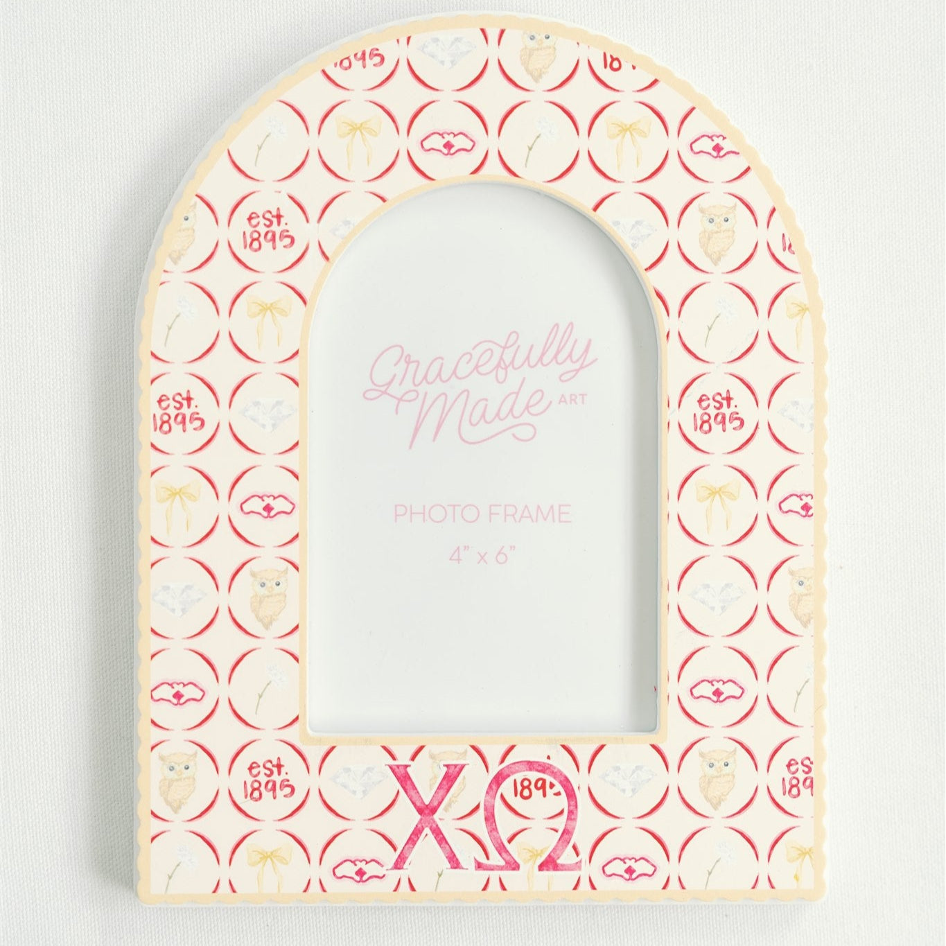 Decorative arch-shaped frame with circular patterns and Chi Omega Greek letters on a light gray background
