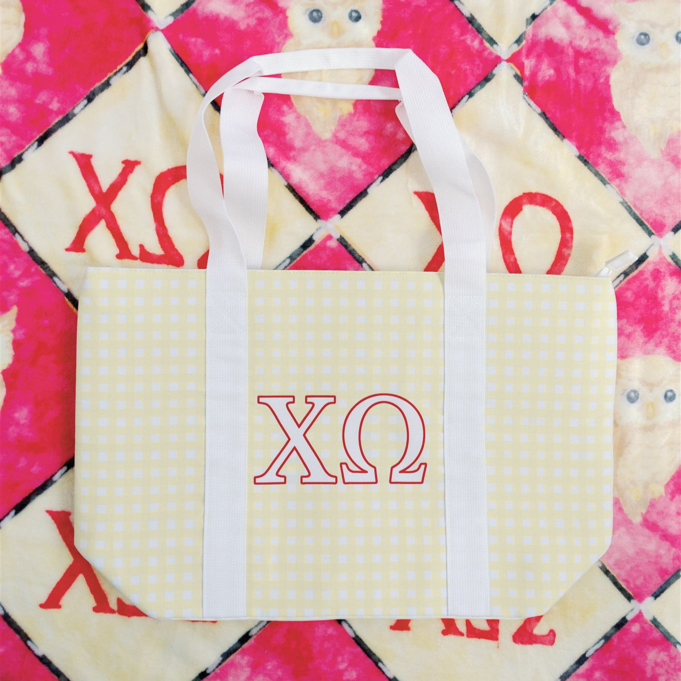 Tote bag with Chi Omega Greek letters on a patterned background