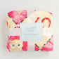 Flannel fleece blanket with a colorful pattern and 'Peacefully Made' label on a light background