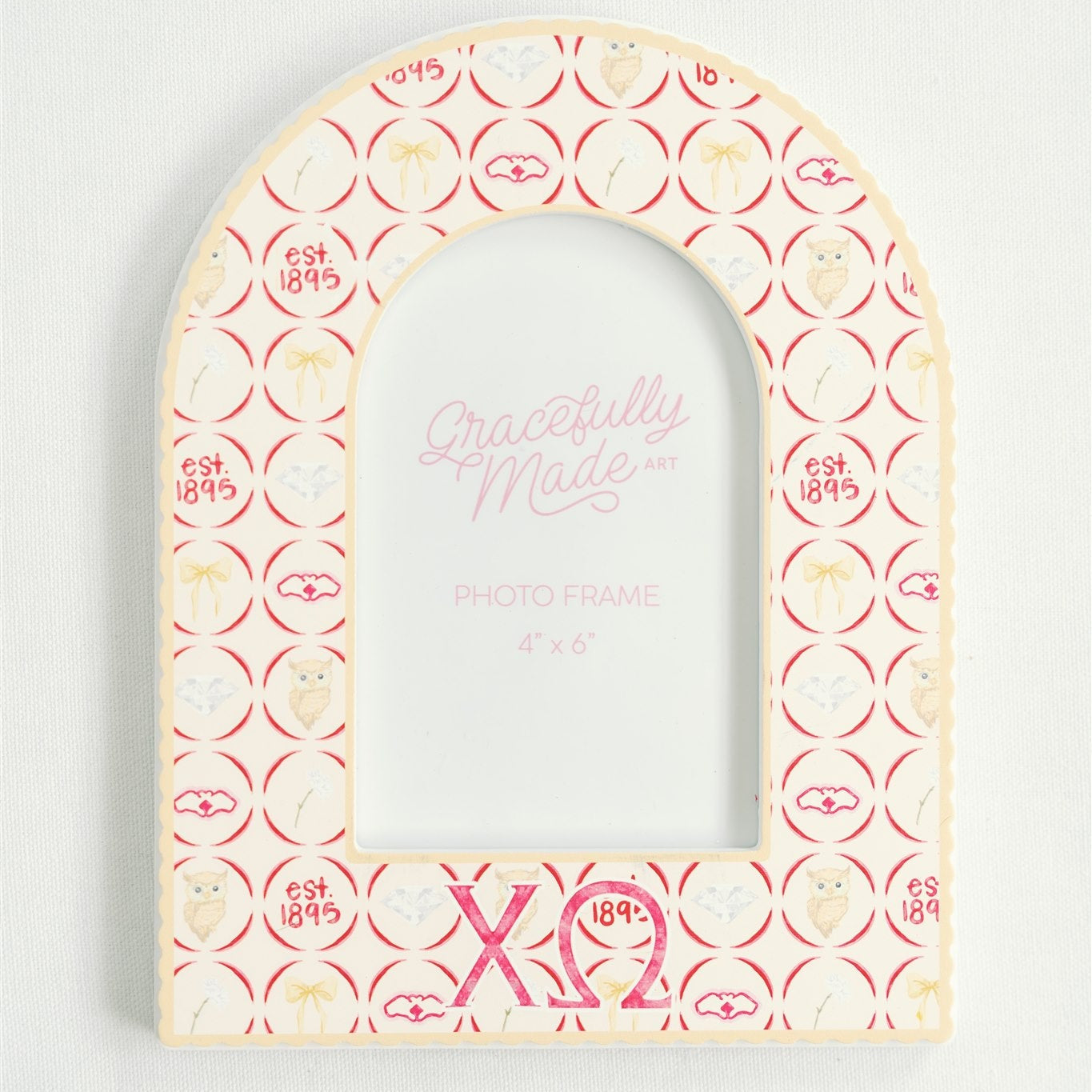 Decorative arched picture frame with Chi Omega pattern and Greek letters on a white background.
