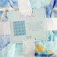 Blanket with Tri Delta watercolor design and text overlay on a matching fabric background