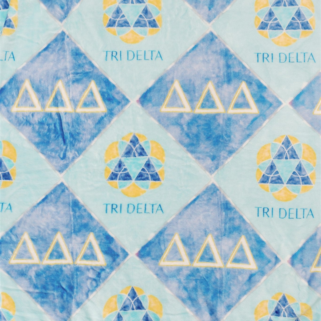 Pattern of TRI DELTA symbols on a light and dark blue background