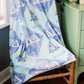 Tri Delta blanket with checkered patterns draped over a chair in a room.