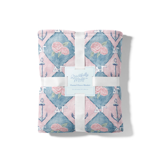 Floral and anchor patterned blanket Delta Gamma symbols on a blue and pink background