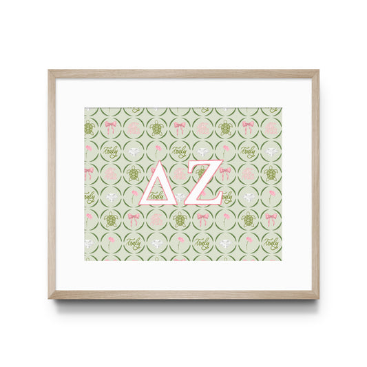 Framed artwork with pink Delta Zeta Greek letters on a patterned background