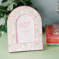 Decorative photo frame with pink and green design and Delta Zeta Greek letters sitting on a green dresser.