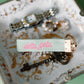 'delta zeta' embroidered in pink on a green keychain.ribbon on a decorative plate with jewelry