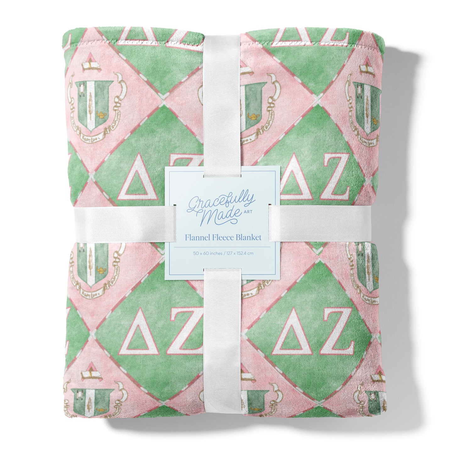 Flannel fleece blanket with pink and green pattern and Delta Zeta Greek letters