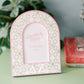 Decorative photo frame with pink and white Delta Zeta design on a green surface