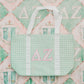 Green checkered tote bag with pink Delta Zeta Greek Letters on a pink and green patterned background