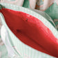 Close-up of a green Delta Zeta tote bag with a bright pink interior liner.
