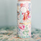 18 ounce insulated water bottle with light pink lid and watercolor Taylor Swift symbols.