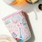 Light pink coffee sleeve with watercolor Taylor Swift inspired symbols.