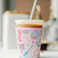 Light pink coffee sleeve with watercolor Taylor Swift inspired symbols.