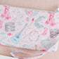 Light pink quilted wristlet with watercolor Taylor Swift symbols as the pattern.