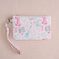 Light pink quilted wristlet with watercolor Taylor Swift symbols as the pattern.