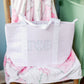 Pink checkered bag with 'Gamma Phi Beta' letters on a chair with floral cushion