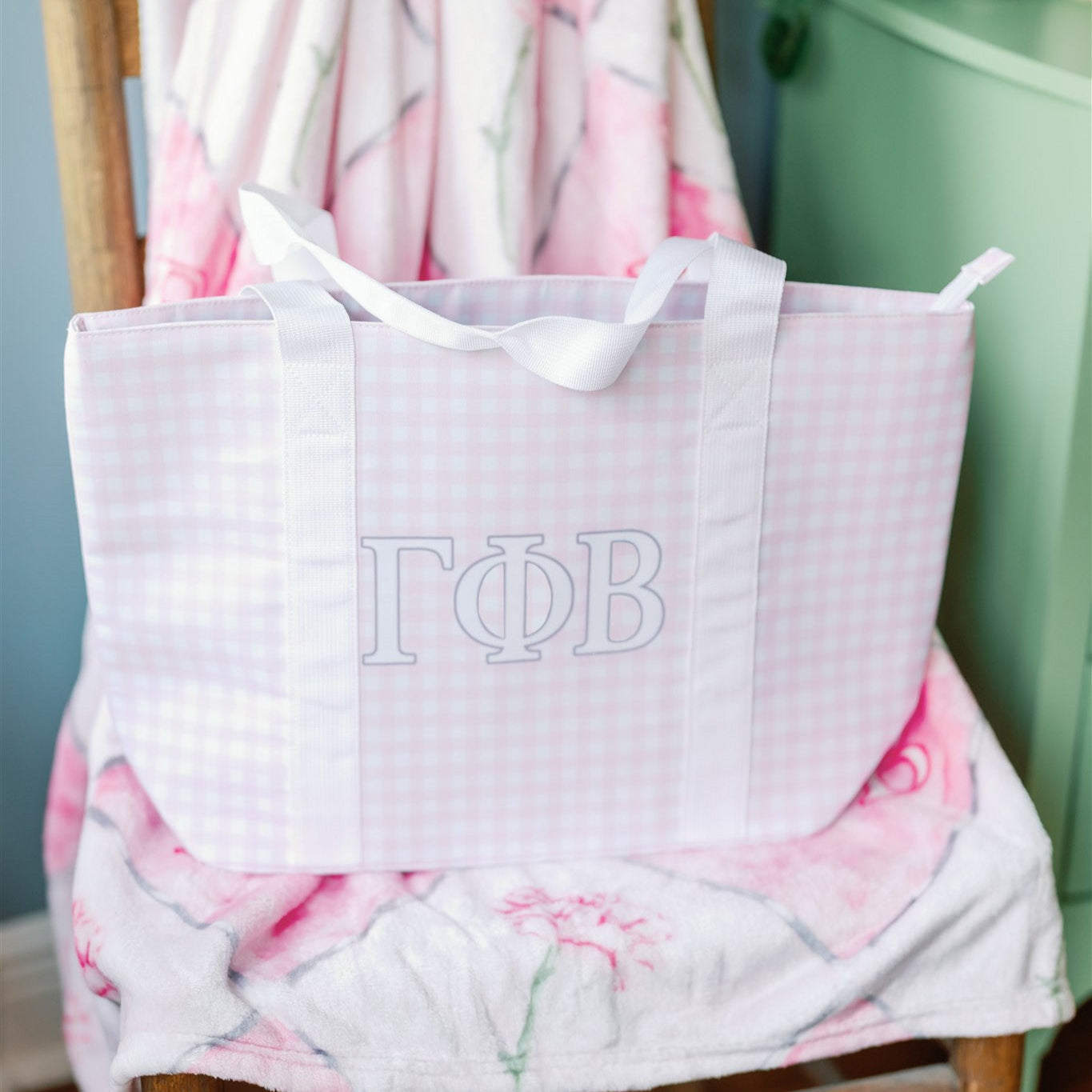 Pink checkered bag with 'Gamma Phi Beta' Greek letters and white straps.