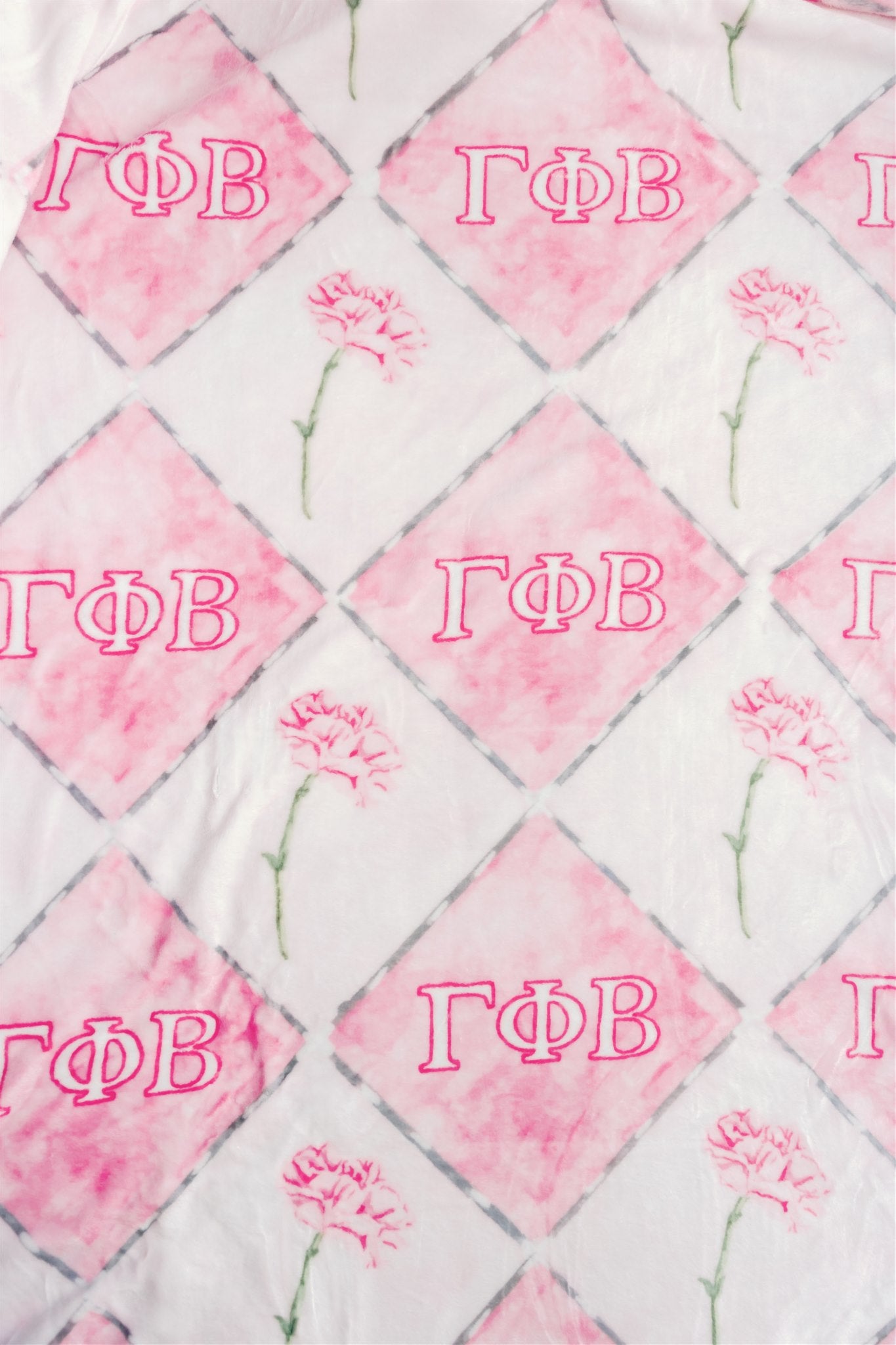 Blanket with flowers and Gamma Phi Beta Greek letters on a dark pink and light pink checkered background