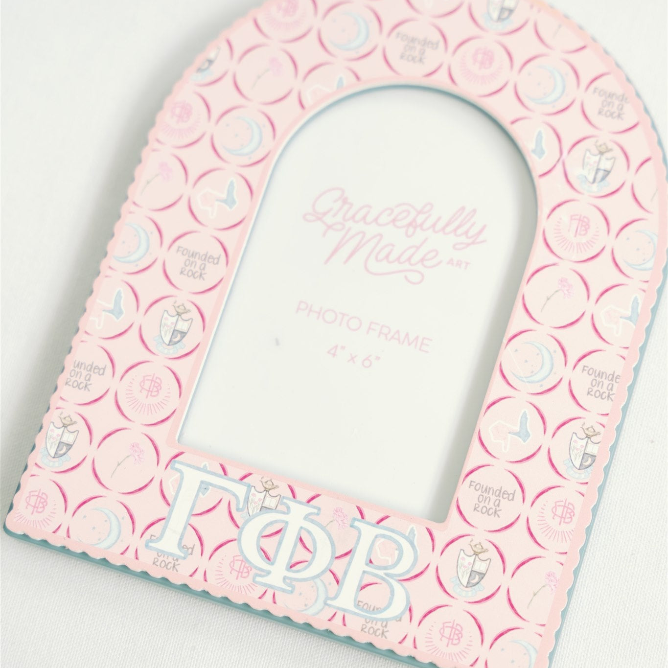 Pink decorative frame with Gamma Phi Beta patterns and Greek letters on a white background