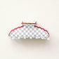 Grey and white checkered hair clip with red scalloped edge.