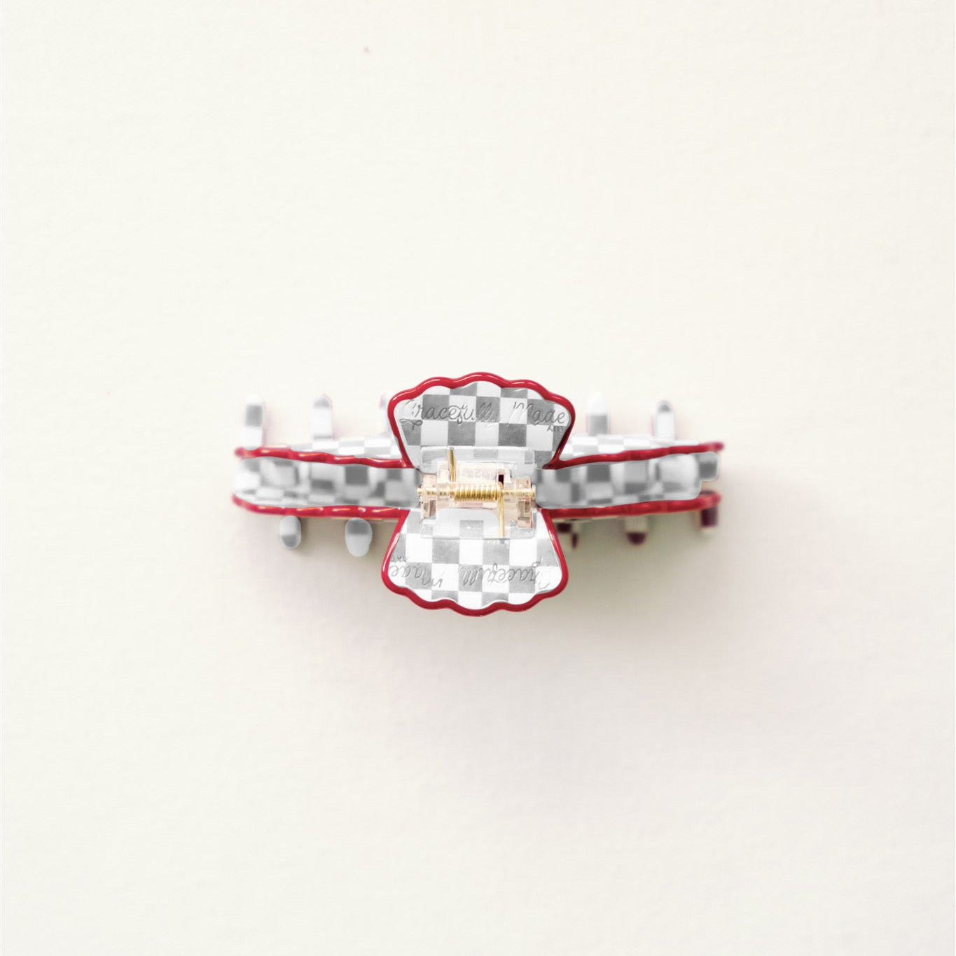 Grey and white claw clip with red scalloped edge.