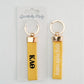 Front and back of a yellow keychain with Kappa Alpha Theta embroidered on it in Gracefully Made Art branded packaging
