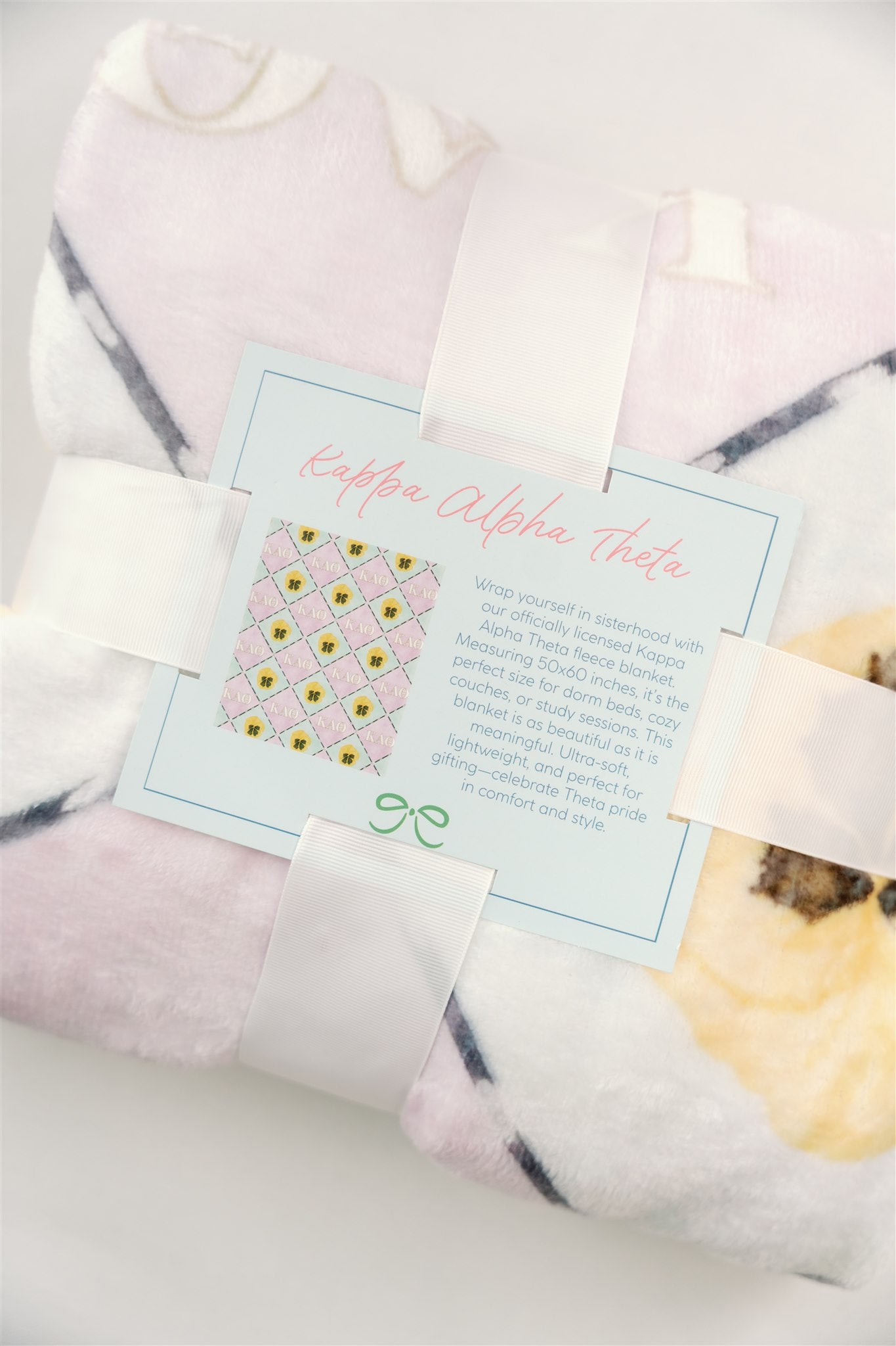 Folded blanket with Kappa Alpha Theta card describing the blanket.