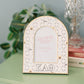 Decorative photo frame with Kappa Alpha Theta pattern and Greek letters on a green dresser.