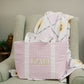 Purple checkered bag with Kappa Alpha Theta Greek letters on a green armchair.
