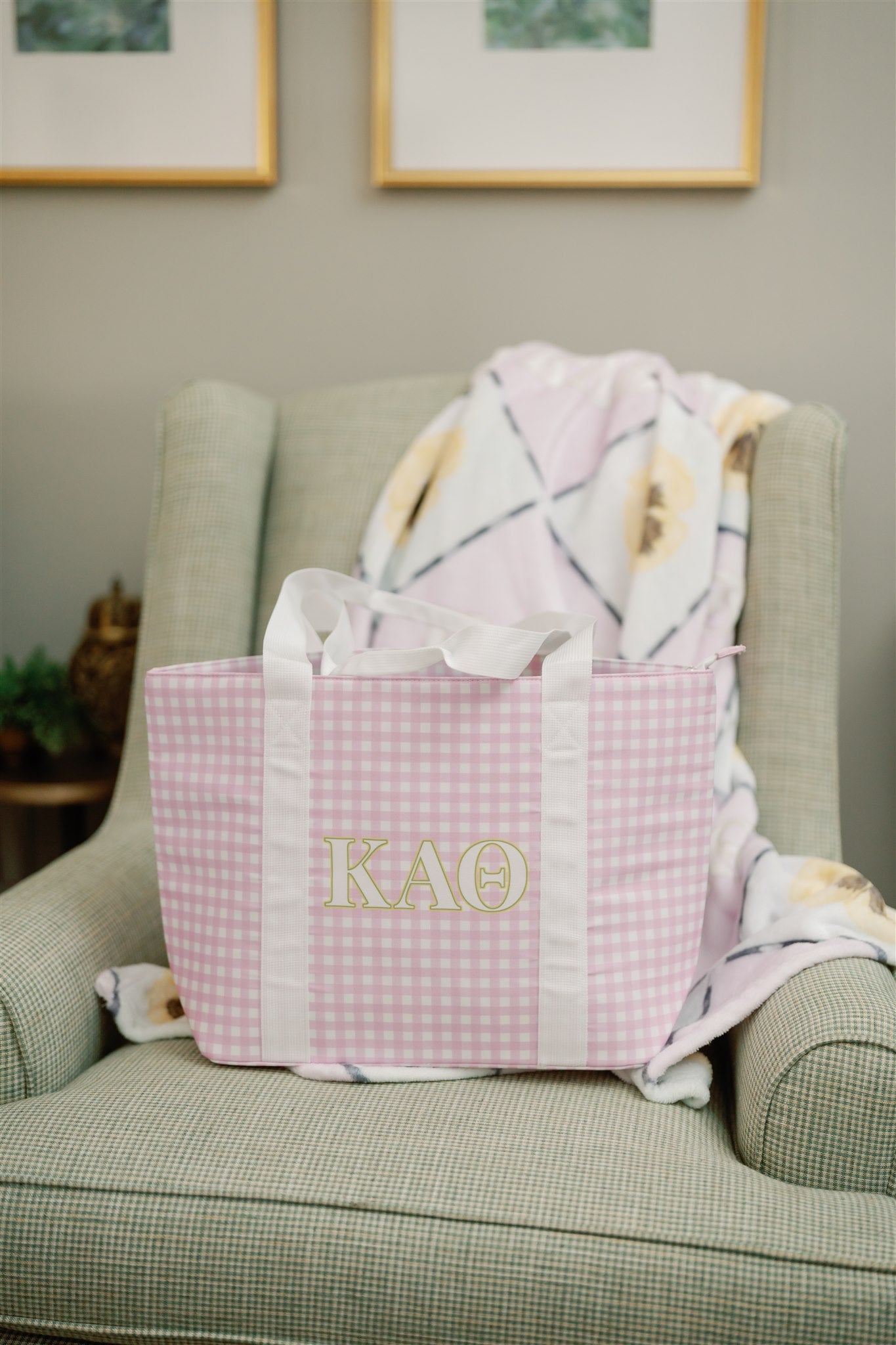 Purple checkered bag with Kappa Alpha Theta Greek letters on a green armchair.