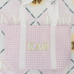 Purple gingham tote bag with 'Kappa Alpha Theta' letters on a patterned background