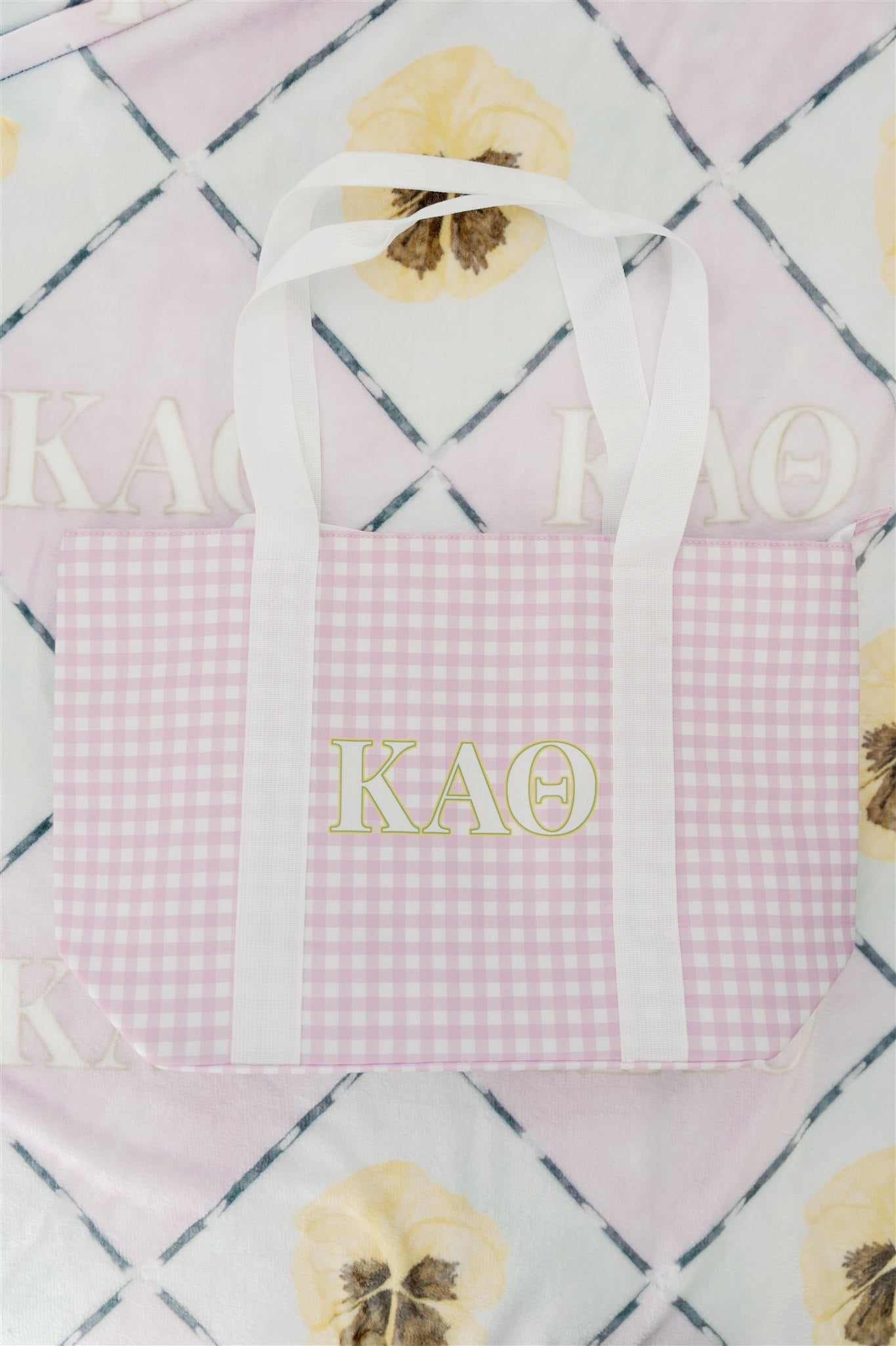 Purple gingham tote bag with 'Kappa Alpha Theta' letters on a patterned background