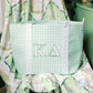 Green checkered bag with 'Kappa Delta' Greek letters on a floral background