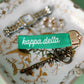 Green 'kappa delta' keychain with vintage keys on a decorative surface