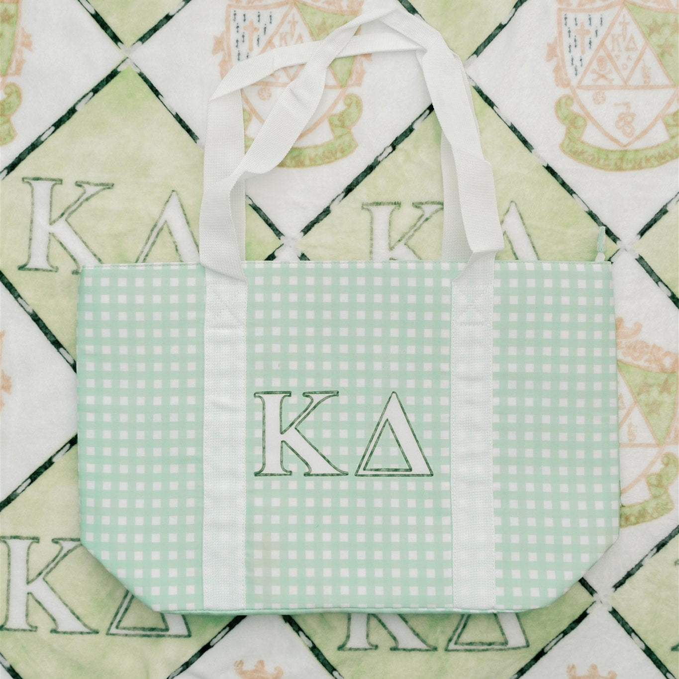 Green checkered tote bag with Kappa Delta letters on a patterned background.