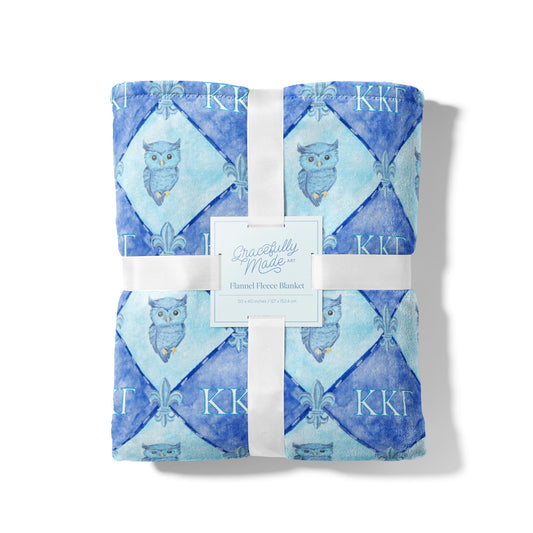Flannel fleece blanket with owl pattern and KKG brand label on a white background