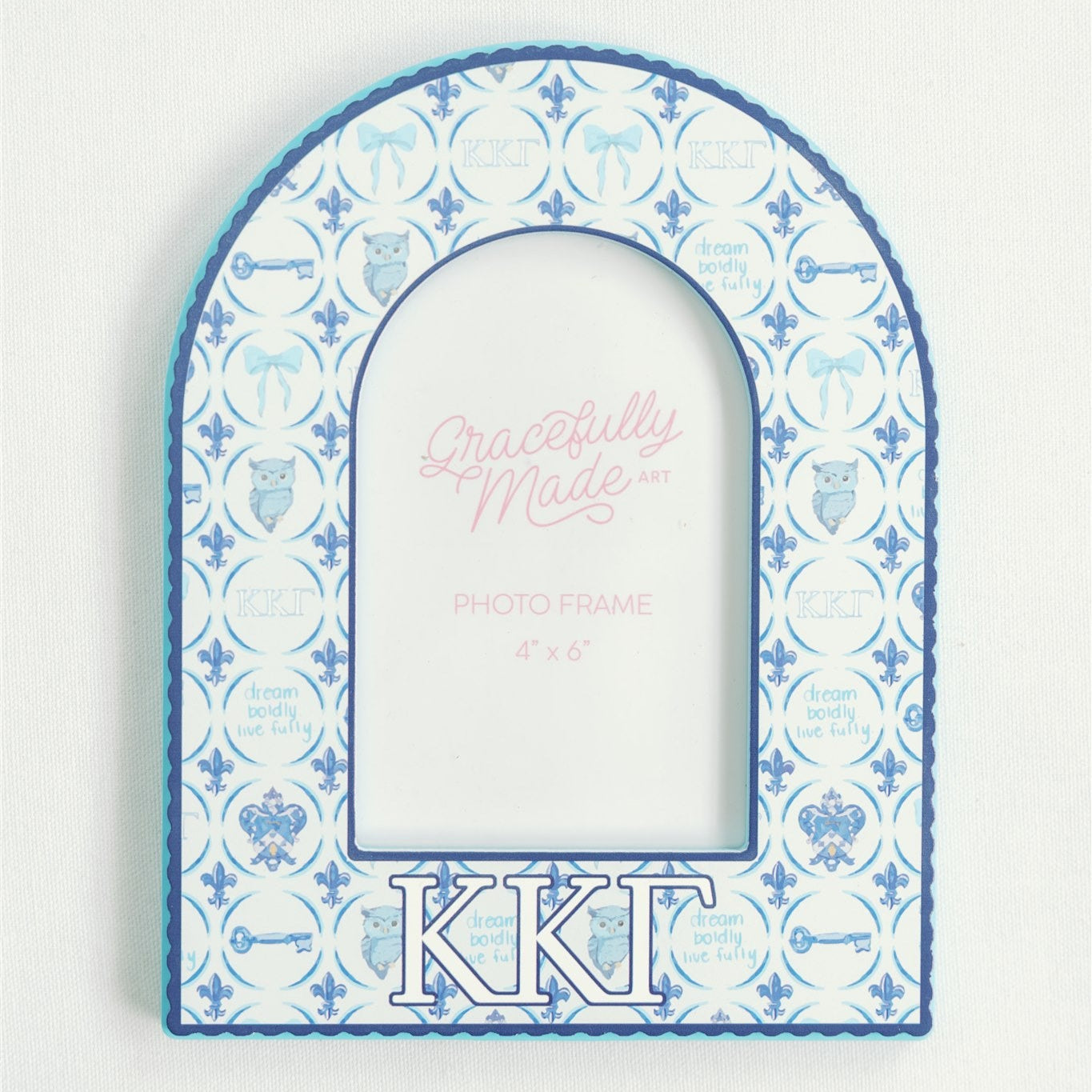 Decorative arched picture frame with blue and white pattern and 'Kappa Kappa Gamma' letters on a light gray background