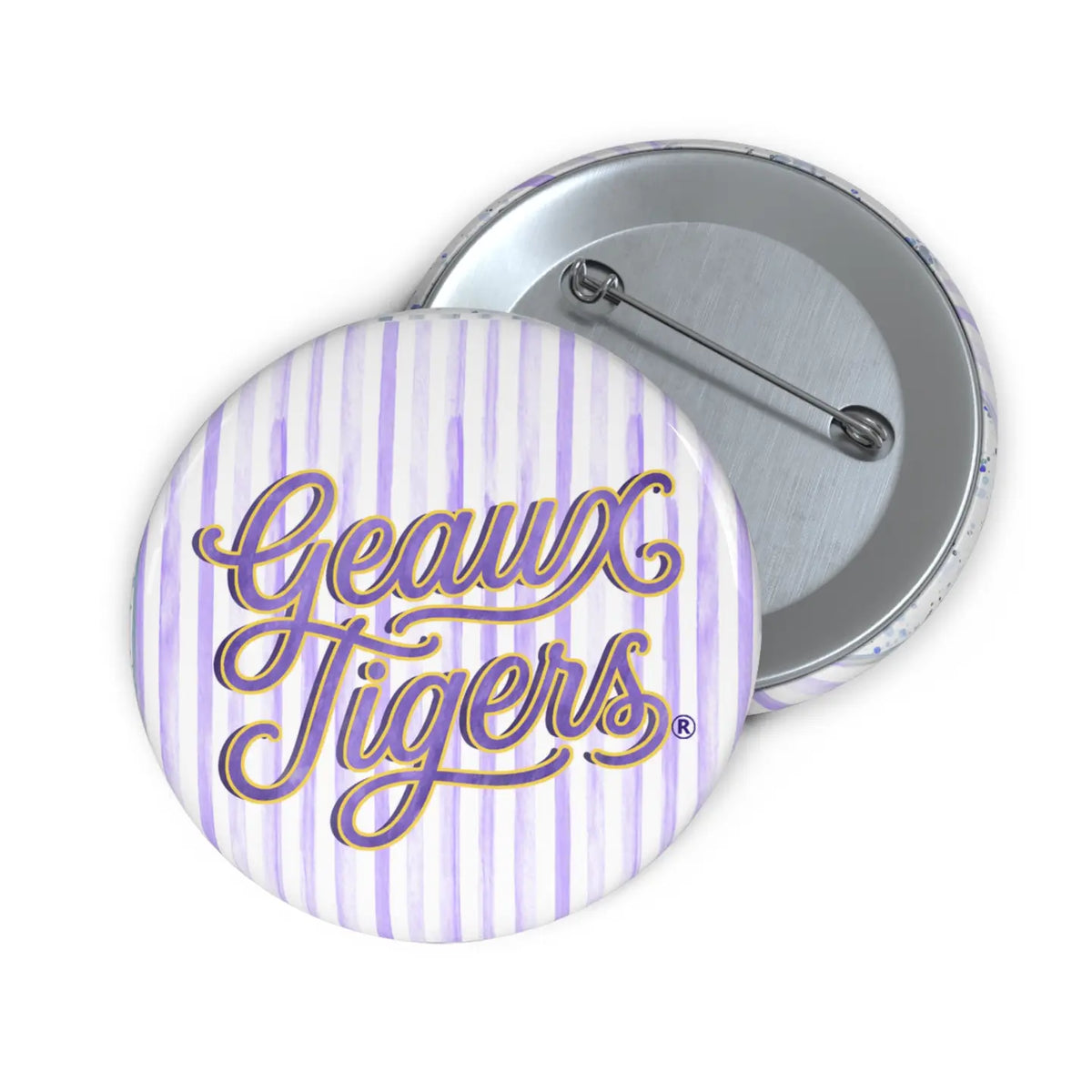 Two round pinback buttons showing the front and back. The front button has a white background with light purple vertical stripes and the words 'Geaux Tigers' in purple cursive with a gold outline.