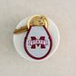 A light grey and maroon keychain with the Mississippi State logo embroidered on it.