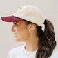 Woman wearing a two-tone baseball cap with a plain background