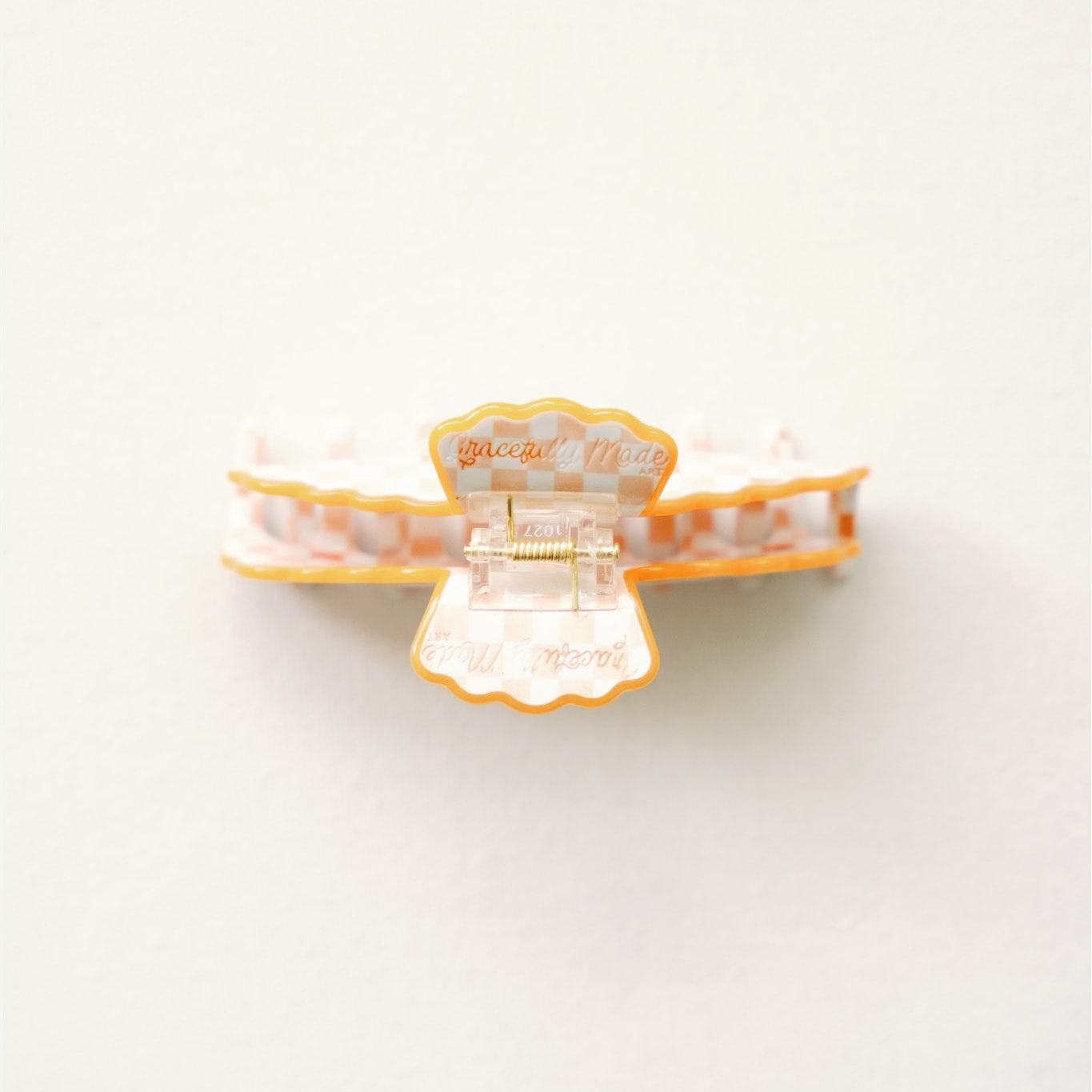 Decorative hair clip with scalloped edge on a white background