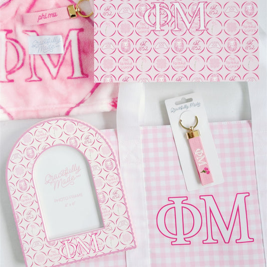 Collection of pink and white items with Phi Mu Greek letters on a white background